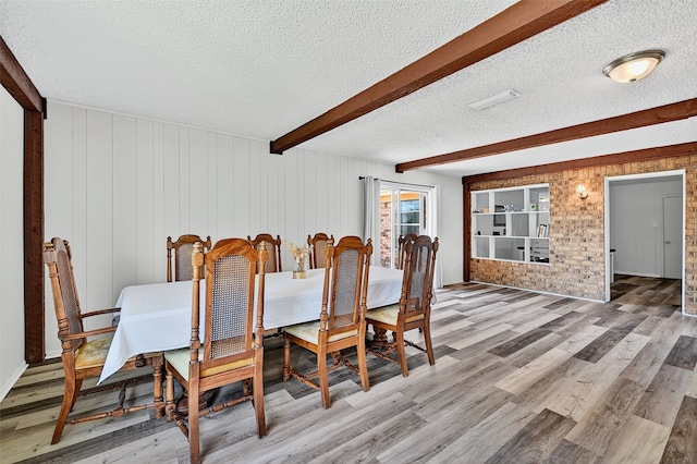 1031 Patricia Dr, Sherman, TX 75090 - dining area with a textured ceiling, light wood finished floors, beam ceiling, and wooden walls