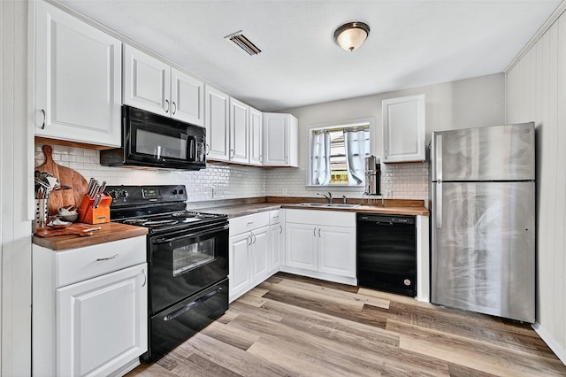 1031 Patricia Dr, Sherman, TX 75090 - kitchen featuring black appliances, wood counters, and white cabinetry