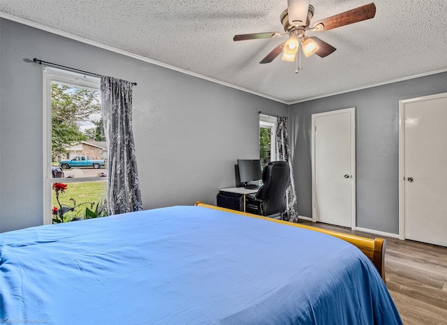 910 Meadowside Cir, Garland, TX 75043 - bedroom with multiple windows, wood finished floors, a textured ceiling, ceiling fan, and an office area