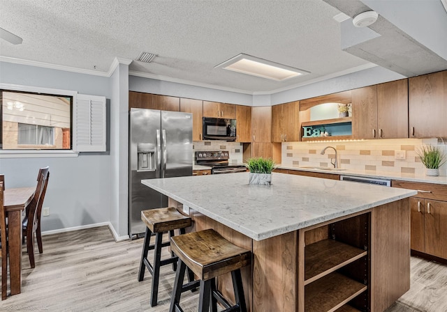 910 Meadowside Cir, Garland, TX 75043 - kitchen with stainless steel appliances, open shelves, a kitchen island, decorative backsplash, and light wood-style floors