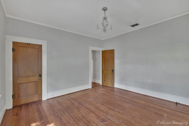 619 College St, Shreveport, LA 71104 - spare room featuring a chandelier, ornamental molding, and wood finished floors