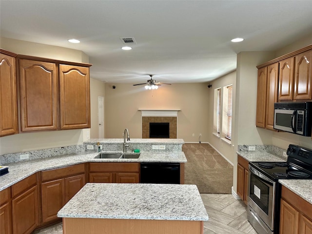 2717 Big Spring Dr, Fort Worth, TX 76120 - kitchen featuring appliances with stainless steel finishes, a ceiling fan, open floor plan, light stone counters, and a peninsula