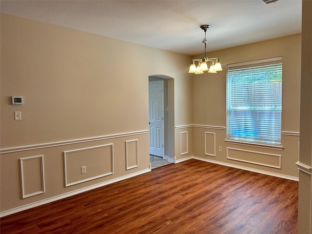 2717 Big Spring Dr, Fort Worth, TX 76120 - unfurnished room with arched walkways, wood finished floors, a chandelier, and a wainscoted wall