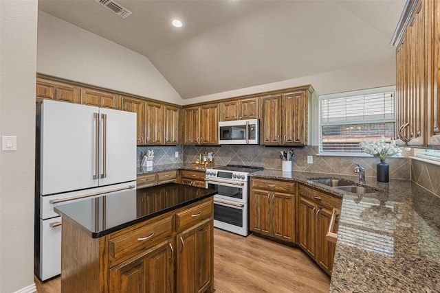 5520 Plata Ln, Benbrook, TX 76126 - kitchen with high quality appliances, vaulted ceiling, light wood-type flooring, backsplash, and a kitchen island