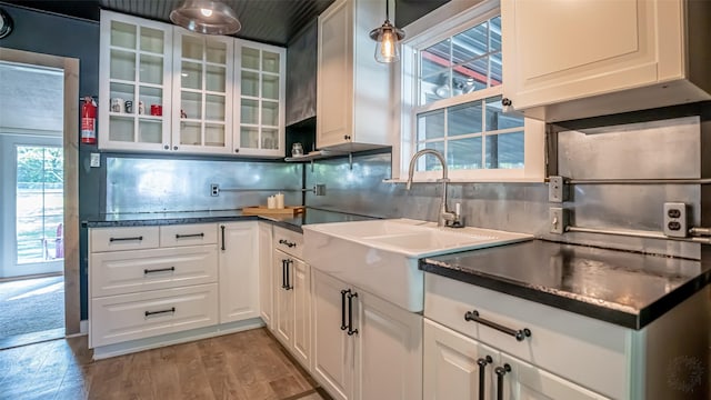 1250 N Isla St, Stephenville, TX 76401 - kitchen featuring tasteful backsplash, white cabinets, glass insert cabinets, light wood-style flooring, and dark countertops