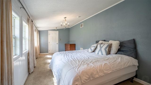 1250 N Isla St, Stephenville, TX 76401 - bedroom with light carpet, a chandelier, ornamental molding, vaulted ceiling, and a textured ceiling