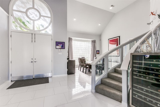 17503 Torrey Pine Dr, Dallas, TX 75287 - tiled foyer with beverage cooler, high vaulted ceiling, stairs, and recessed lighting