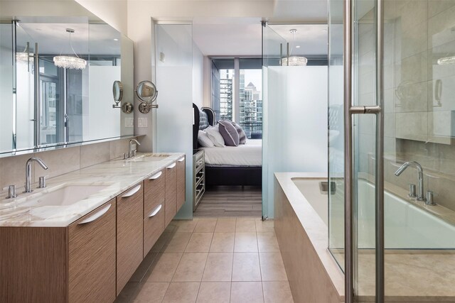 2900 Mckinnon St Unit 1001, Dallas, TX 75201 - ensuite bathroom featuring a relaxing tiled tub, double vanity, tile patterned flooring, and an enclosed shower