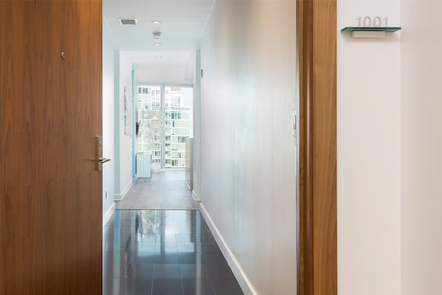 2900 Mckinnon St Unit 1001, Dallas, TX 75201 - hallway featuring baseboards and dark tile patterned floors