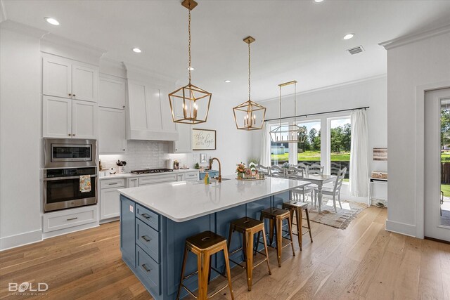 10946 Whispering Path Dr, Shreveport, LA 71106 - kitchen with appliances with stainless steel finishes, white cabinetry, light countertops, backsplash, and light wood finished floors