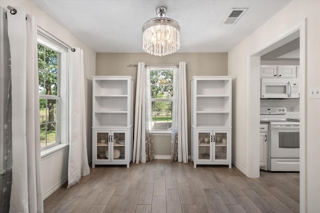 7720 Angelina Dr, Athens, TX 75752 - unfurnished dining area featuring a chandelier and wood finished floors