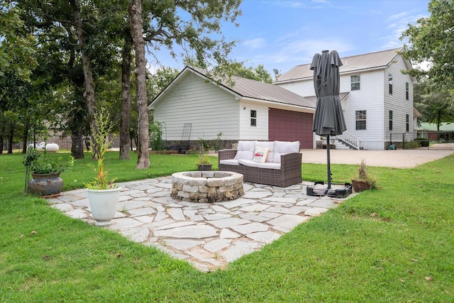 7720 Angelina Dr, Athens, TX 75752 - back of house with a patio, a metal roof, a garage, and an outdoor living space with a fire pit