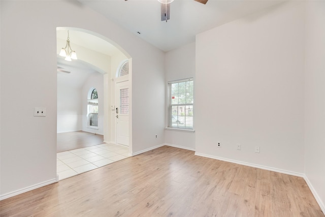 1647 Ash Ln, Corinth, TX 76210 - unfurnished room featuring ceiling fan, vaulted ceiling, arched walkways, light wood finished floors, and healthy amount of natural light