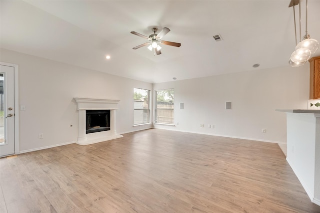1647 Ash Ln, Corinth, TX 76210 - unfurnished living room featuring a fireplace with raised hearth, ceiling fan, and light wood-type flooring