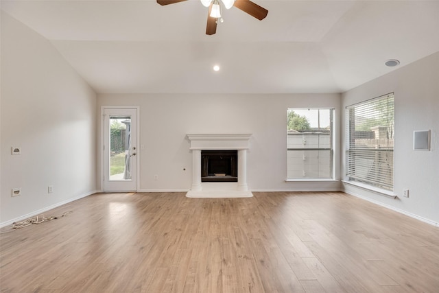 1647 Ash Ln, Corinth, TX 76210 - unfurnished living room featuring lofted ceiling, a ceiling fan, a fireplace with raised hearth, and light wood-style floors