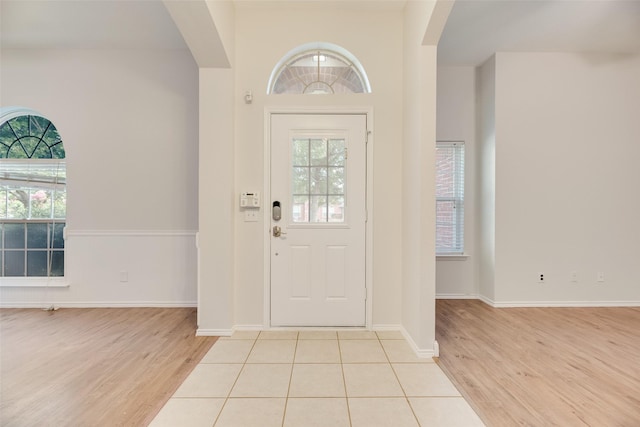 1647 Ash Ln, Corinth, TX 76210 - foyer featuring arched walkways, light wood finished floors, and plenty of natural light