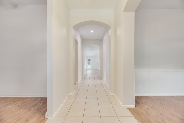 1647 Ash Ln, Corinth, TX 76210 - hall with arched walkways, light wood-type flooring, and wainscoting