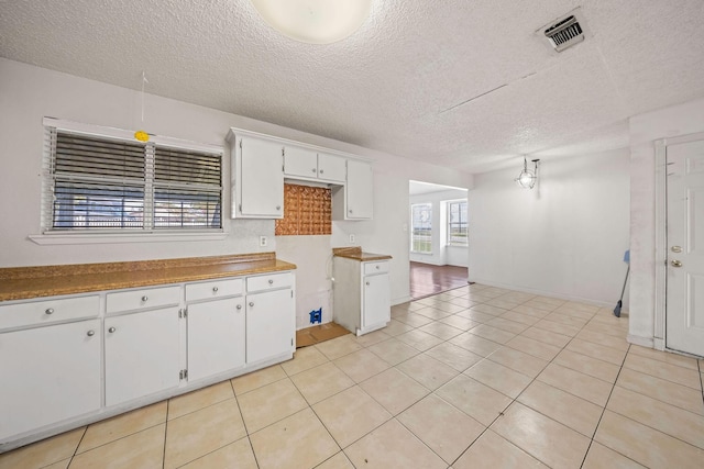 101 Arrowhead St, Fort Worth, TX 76108 - kitchen featuring a textured ceiling, white cabinetry, and light tile patterned flooring