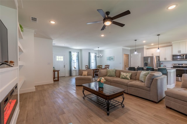 5523 Firewood Trl, Granbury, TX 76048 - living area featuring a ceiling fan, light wood-style floors, crown molding, recessed lighting, and a chandelier