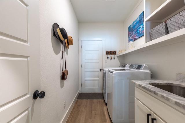 5523 Firewood Trl, Granbury, TX 76048 - washroom featuring washing machine and clothes dryer, light wood-style flooring, and cabinet space