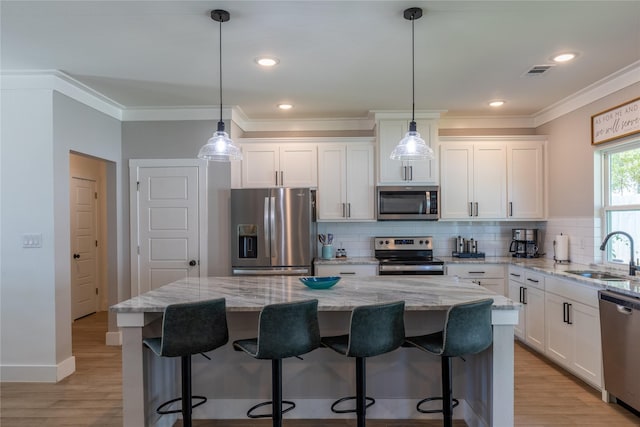 5523 Firewood Trl, Granbury, TX 76048 - kitchen with appliances with stainless steel finishes, ornamental molding, white cabinets, backsplash, and a center island