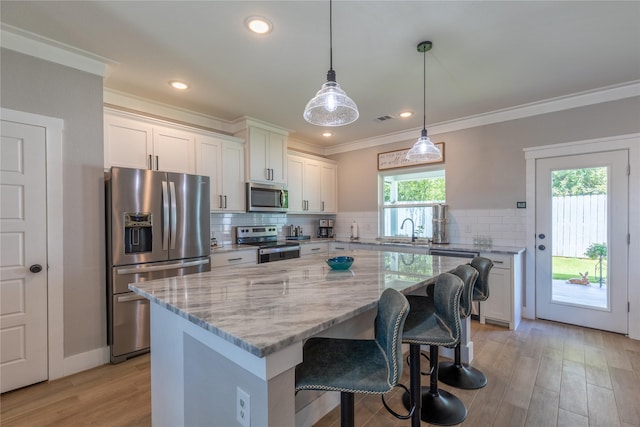 5523 Firewood Trl, Granbury, TX 76048 - kitchen with stainless steel appliances, a kitchen island, white cabinetry, light stone countertops, and tasteful backsplash