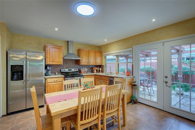 5610 Christie Ln, Garland, TX 75044 - kitchen featuring appliances with stainless steel finishes, wall chimney exhaust hood, light countertops, light brown cabinets, and recessed lighting