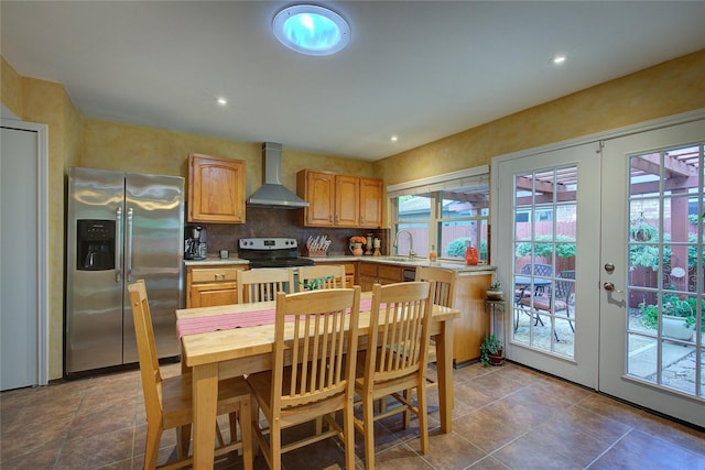 5610 Christie Ln, Garland, TX 75044 - kitchen with appliances with stainless steel finishes, wall chimney range hood, light countertops, french doors, and recessed lighting