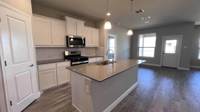 1821 Brindle St, Northlake, TX 76247 - kitchen with stainless steel appliances, dark wood-style floors, decorative backsplash, a center island with sink, and white cabinetry