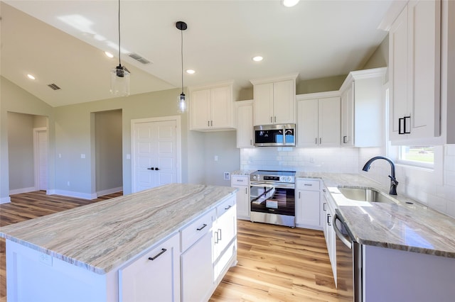 148 Crescent St, Bullard, TX 75757 - kitchen featuring appliances with stainless steel finishes, light wood-style flooring, decorative backsplash, light stone countertops, and recessed lighting