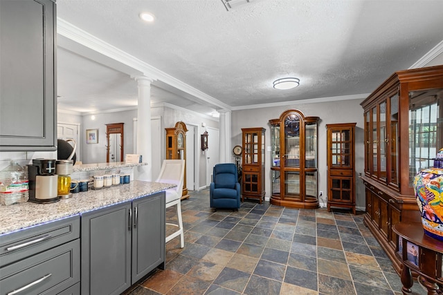 6301 Shadydell Dr, Fort Worth, TX 76135 - kitchen featuring gray cabinets, decorative columns, ornamental molding, a textured ceiling, and dark stone finish flooring