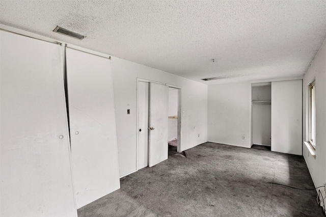 1801 Plantation Rd, Garland, TX 75044 - unfurnished bedroom featuring a textured ceiling, multiple closets, and carpet