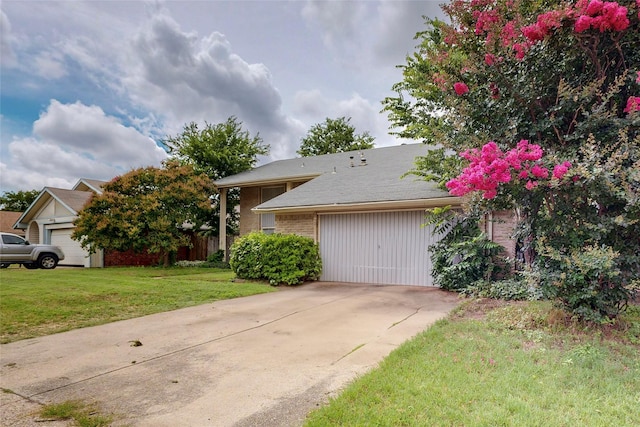 1801 Plantation Rd, Garland, TX 75044 - view of front of home with concrete driveway, a garage, and a front lawn