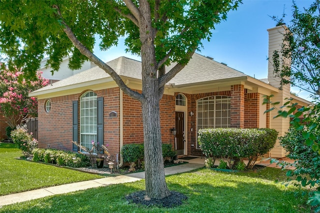 661 Raintree Cir, Coppell, TX 75019 - view of front facade featuring brick siding, a chimney, a front lawn, and roof with shingles