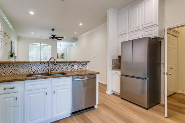 661 Raintree Cir, Coppell, TX 75019 - kitchen featuring appliances with stainless steel finishes, crown molding, light wood finished floors, a ceiling fan, and backsplash