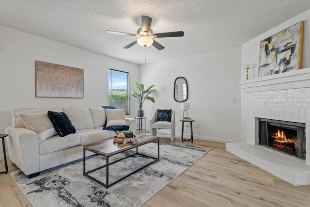 3300 Jacobs Dr, Mckinney, TX 75070 - living room with ceiling fan, a fireplace, wood finished floors, and a textured ceiling