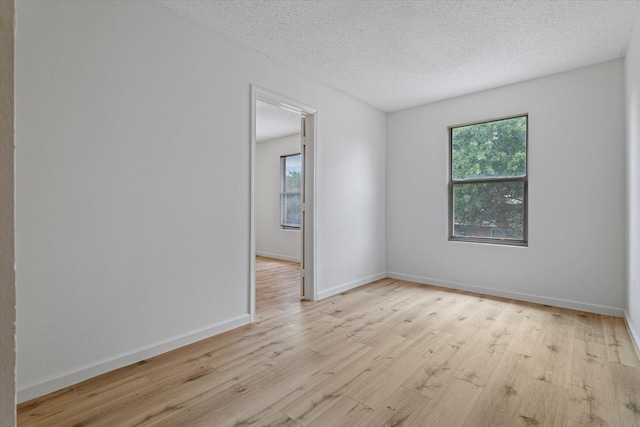 3300 Jacobs Dr, Mckinney, TX 75070 - empty room with plenty of natural light, wood finished floors, and a textured ceiling