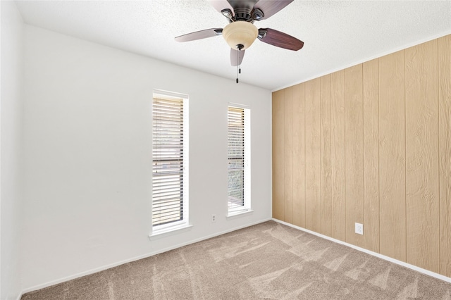 2911 W Day St, Denison, TX 75020 - empty room featuring wooden walls, carpet, a ceiling fan, and a textured ceiling
