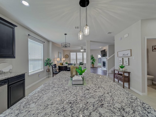 2460 Open Range Dr, Fort Worth, TX 76177 - kitchen with dishwasher, light stone countertops, dark cabinets, open floor plan, and decorative light fixtures