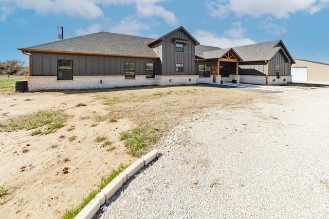 217 Polk, Bowie, TX 76230 - rear view of house featuring board and batten siding, a shingled roof, and brick siding