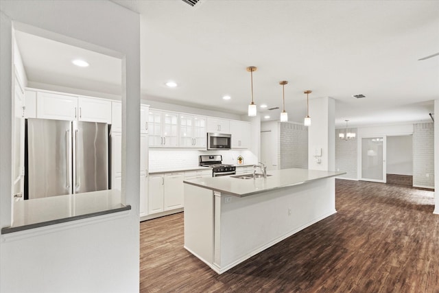 8620 S County Rd, Frisco, TX 75034 - kitchen featuring stainless steel appliances, dark wood-type flooring, white cabinets, an island with sink, and decorative backsplash