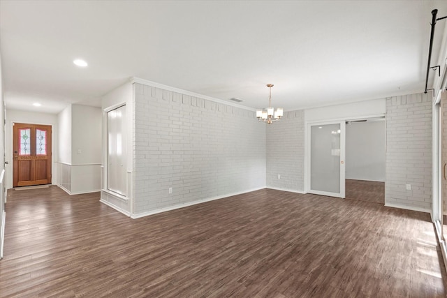 8620 S County Rd, Frisco, TX 75034 - empty room featuring brick wall, dark wood finished floors, and a chandelier