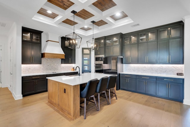 140 Friesian Ln, Waxahachie, TX 75167 - kitchen with stainless steel appliances, light wood-style floors, premium range hood, a chandelier, and coffered ceiling
