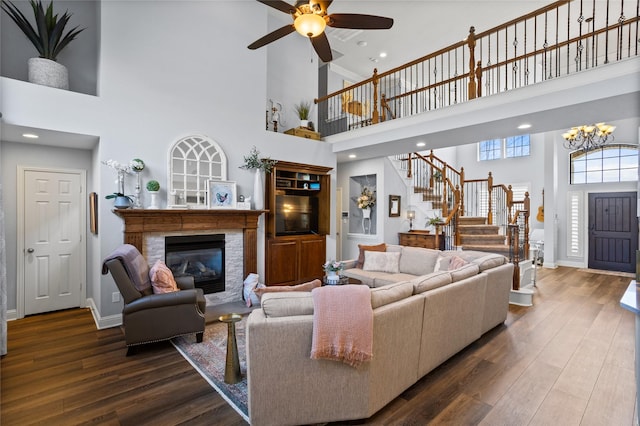 826 Mustang Ridge Dr, Murphy, TX 75094 - living area featuring a towering ceiling, stairway, a glass covered fireplace, a ceiling fan, and wood finished floors
