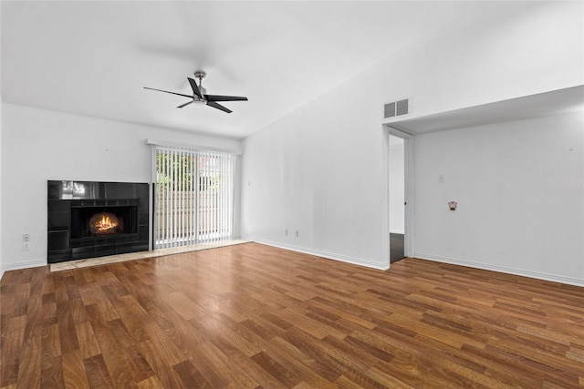350 W Harwood Rd Unit A, Hurst, TX 76054 - unfurnished living room with ceiling fan, wood finished floors, a tiled fireplace, and vaulted ceiling