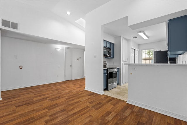 350 W Harwood Rd Unit A, Hurst, TX 76054 - kitchen featuring stainless steel appliances, blue cabinets, light wood finished floors, light countertops, and recessed lighting