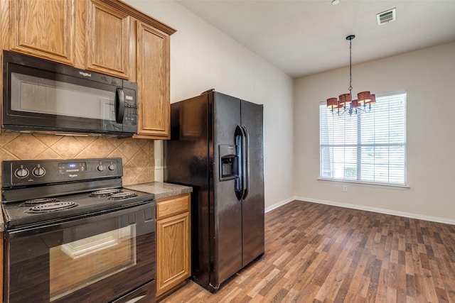 2836 Fordham Rd, Plano, TX 75025 - kitchen with black appliances, decorative backsplash, a chandelier, light wood-style flooring, and light countertops