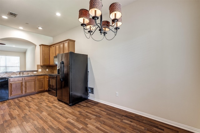 2836 Fordham Rd, Plano, TX 75025 - kitchen with black appliances, arched walkways, dark wood-style flooring, tasteful backsplash, and a chandelier