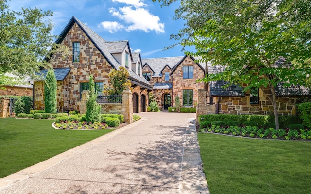 2307 Cedar Elm Ter, Westlake, TX 76262 - tudor house featuring stone siding, driveway, a front lawn, and a garage