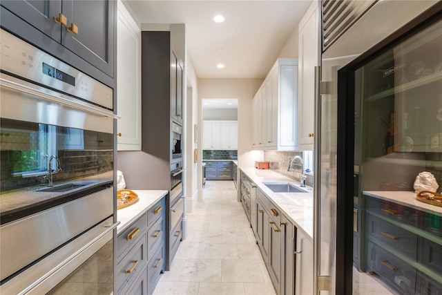 2307 Cedar Elm Ter, Westlake, TX 76262 - kitchen featuring decorative backsplash, double oven, white cabinetry, recessed lighting, and light stone counters
